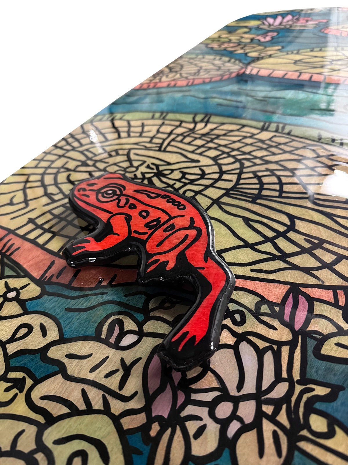 Detail — raised, separately cut red frog under glossy acrylic resin